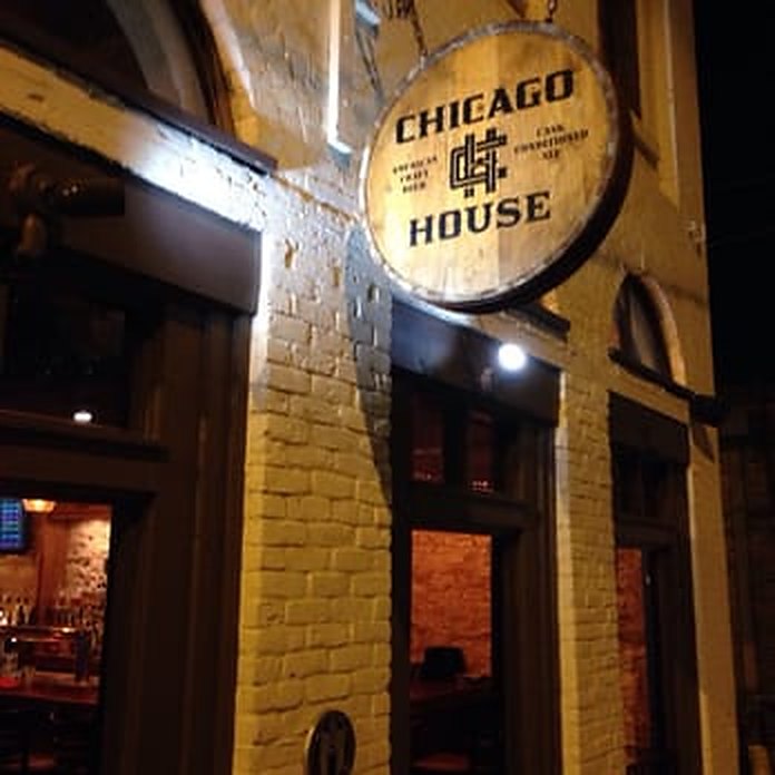 The Chicago House sign glowing at night in downtown Austin